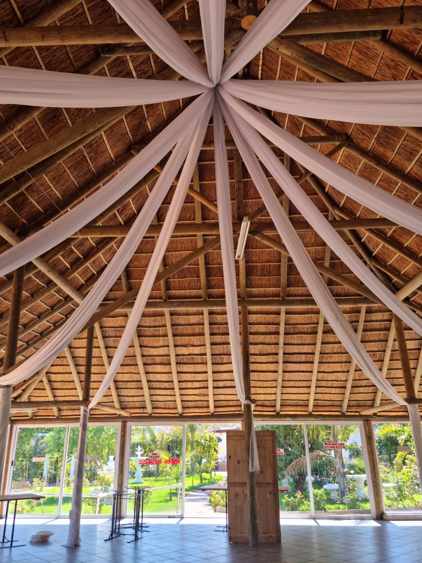 Guest tables beneath the thatched roof