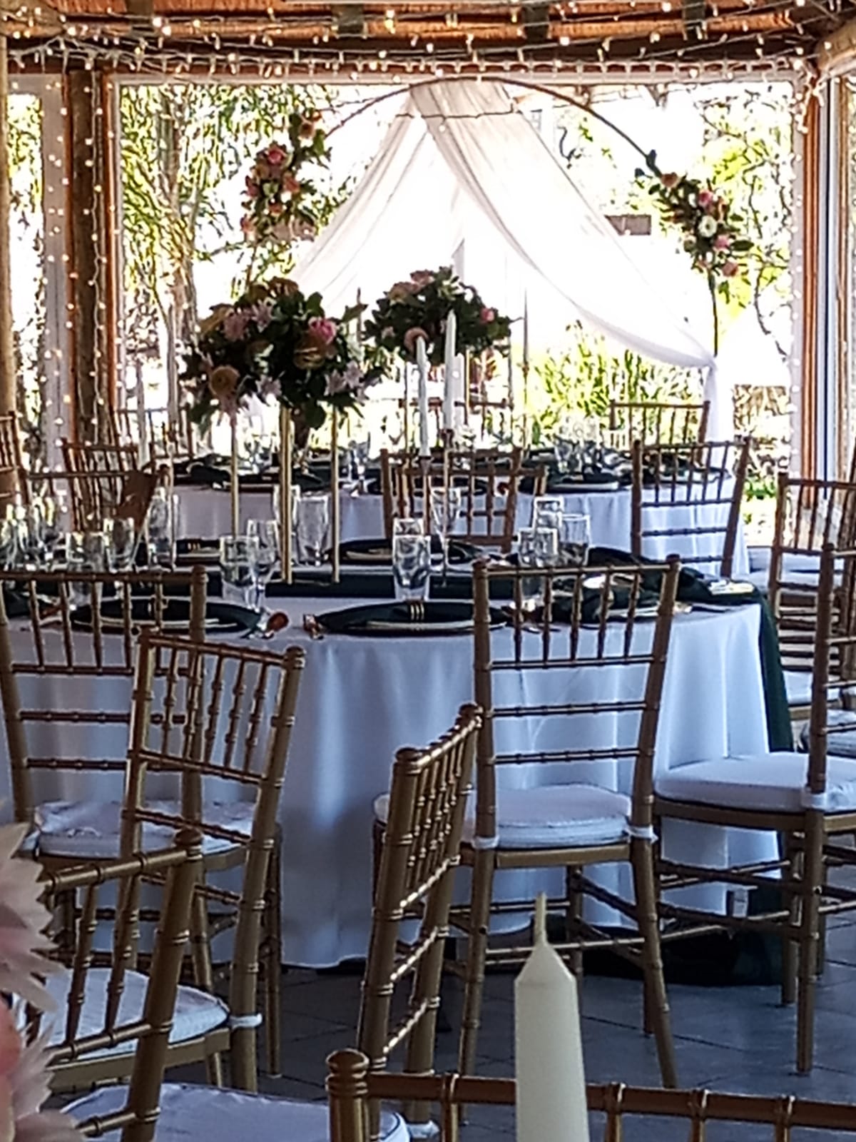 Gold chairs with pink floral centrepieces