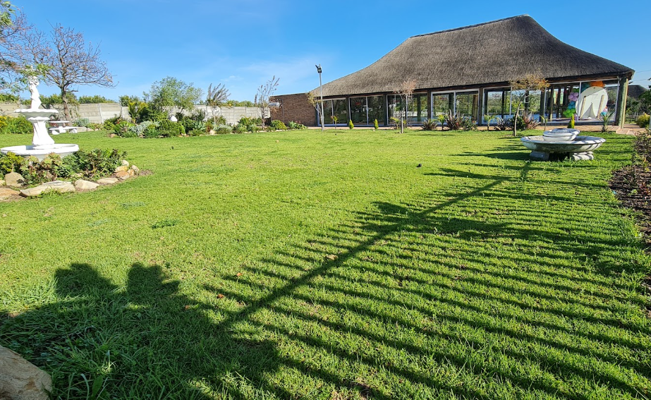 Manicured lawns in front of the Top Prima thatched hall