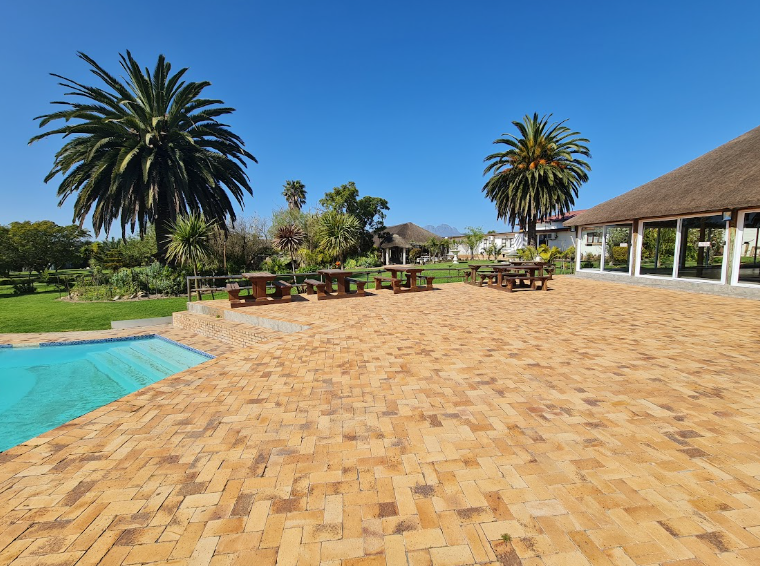 Paved courtyard, pool and picnic benches at Nativitus
