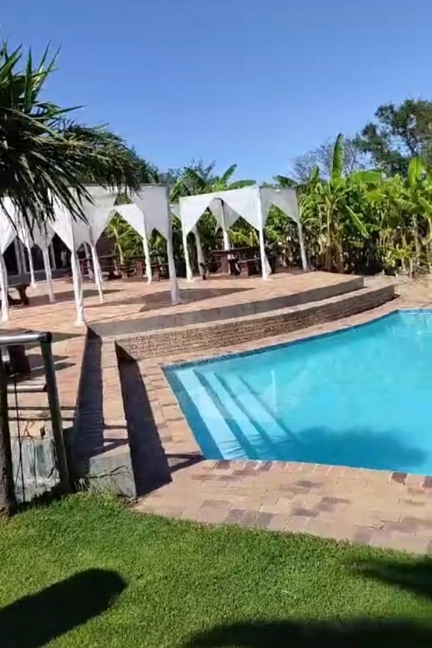Swimming pool and lawns with white gazebos